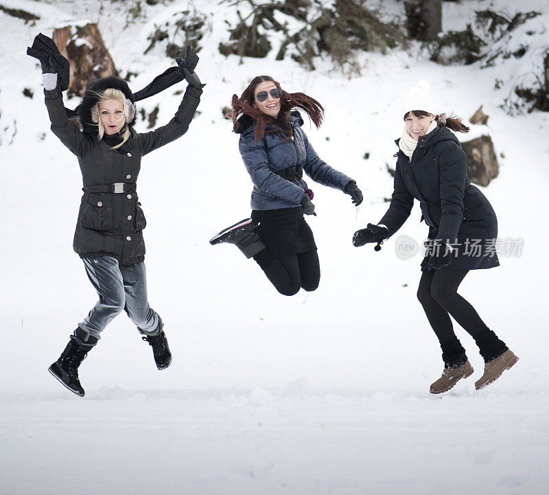 三个女孩在雪中跳跃