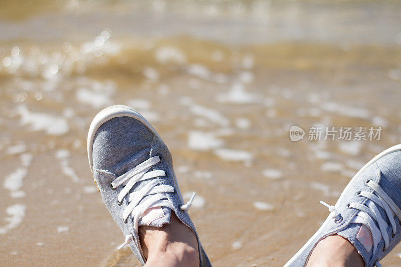 海滩度假:脚在网球鞋附近冲浪