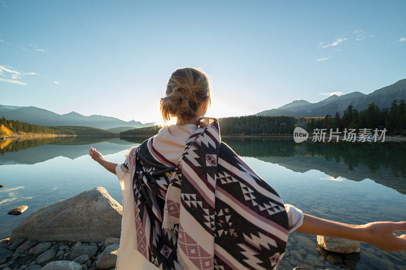 欢呼的女人张开双臂迎接日出