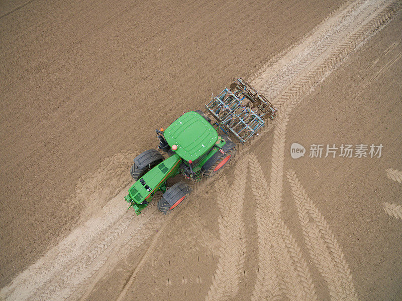 拖拉机-鸟瞰图拖拉机在耕作的田野在春天