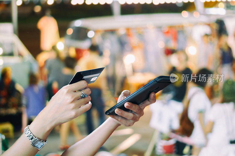 亚洲女性使用智能手机和信用卡在网上购物，选择性地专注于手头