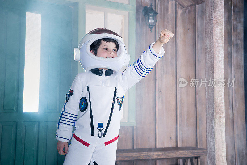 穿着宇航员服装的男孩在走廊上飞行