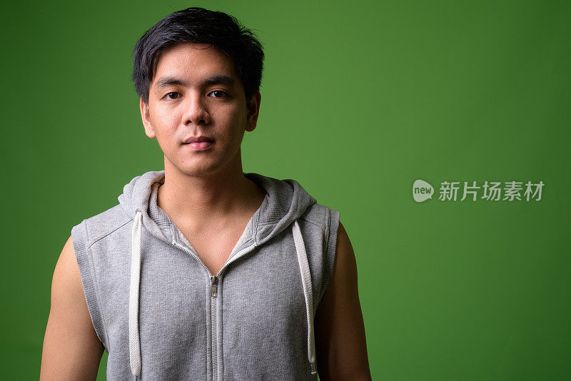 绿色背景下的年轻亚洲男子的肖像
