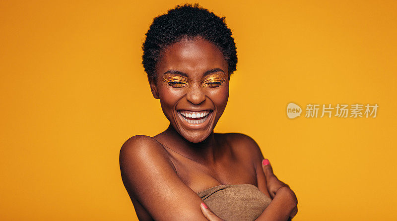 一个非洲女人在黄色的背景下笑
