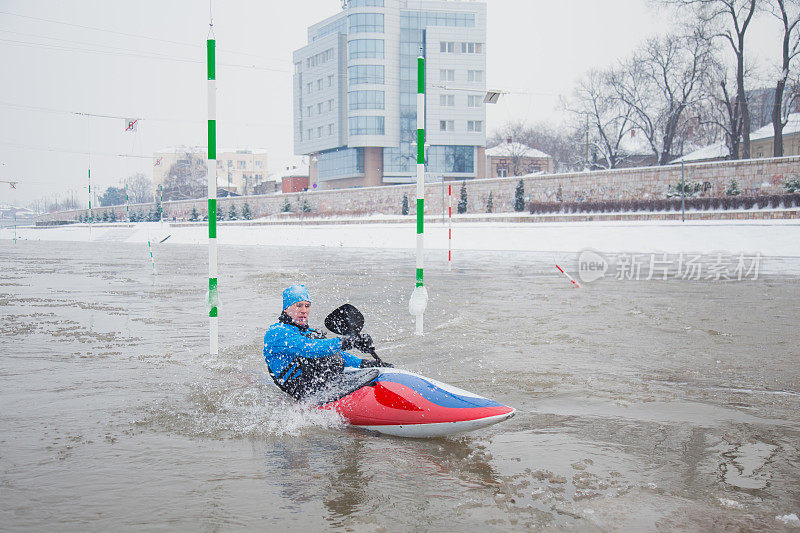 强壮的运动员在冷水中骑着皮划艇