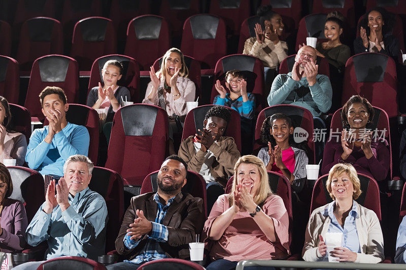 多民族观众在电影院鼓掌