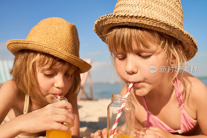 可爱的女孩在海滩上喝清爽的饮料