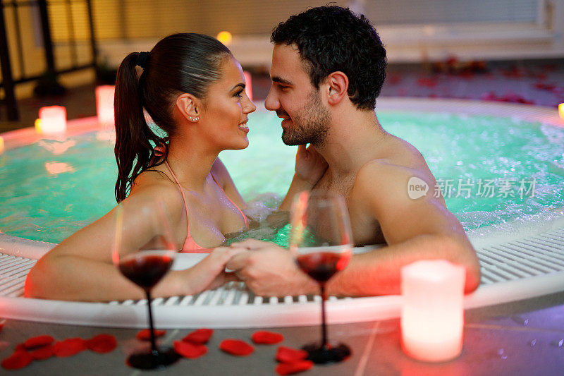 一对美丽的夫妇在健康水疗中心的热水浴缸里放松