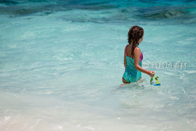 小女孩戴着水肺面具在海洋中探险