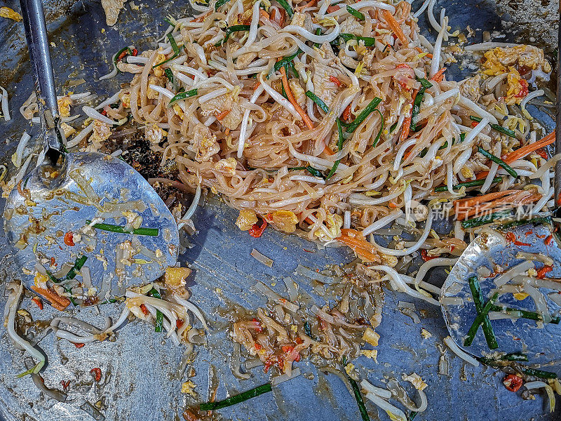 烹饪泰国著名的街头食品菜叫做“泰式”,这是一个菜炒的面条,豆芽,蔬菜鸡肉和虾,裹着一层薄薄的omlette。