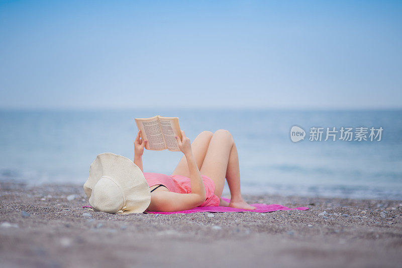 悠闲的女人在海边看书