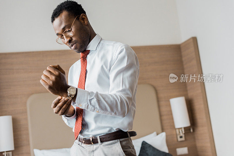 非裔美国商人戴着手表在酒店房间
