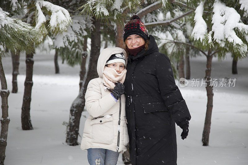 妈妈和女儿在雪中玩耍