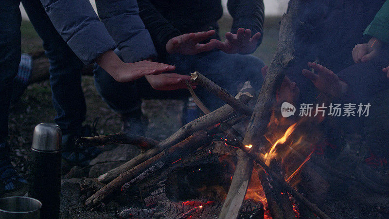 一家人在篝火旁取暖。冬天的乐趣。城市的河滨