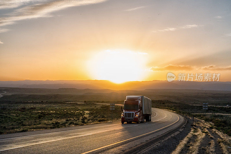 在一个戏剧性的天空下的黄昏高速公路上的长途半挂车