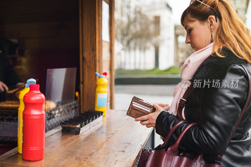 带钱包的年轻女子拿钱去吃快餐