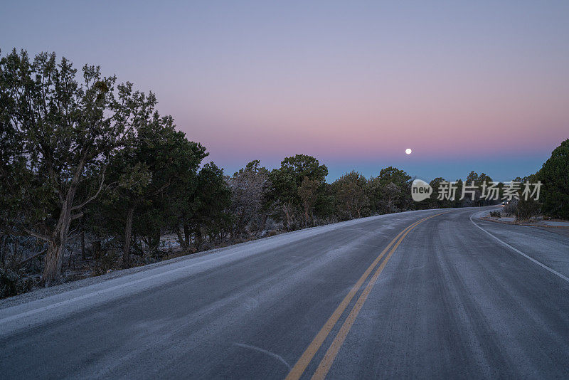美国亚利桑那州，黎明时分，满月下粉红天空的大峡谷景色令人惊叹