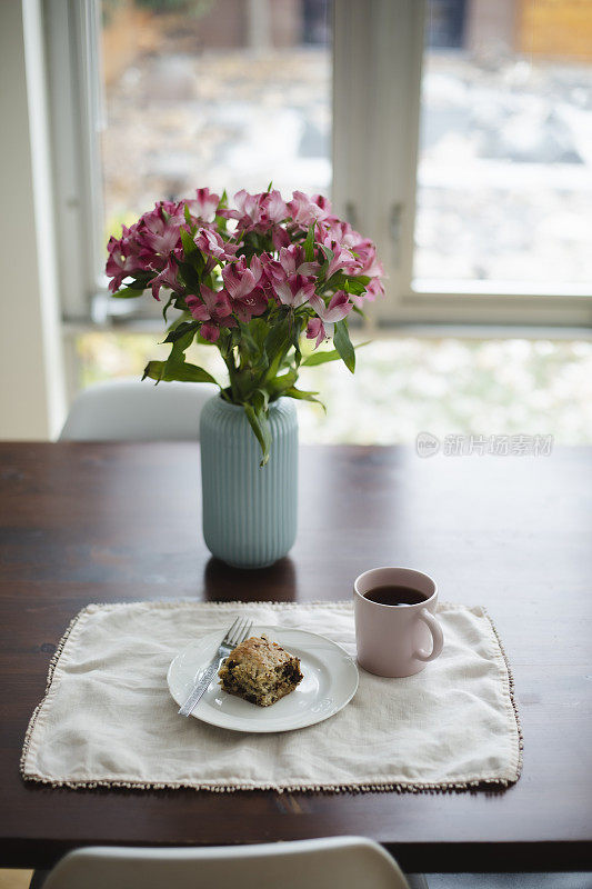 桌子上有蛋糕、咖啡和鲜花
