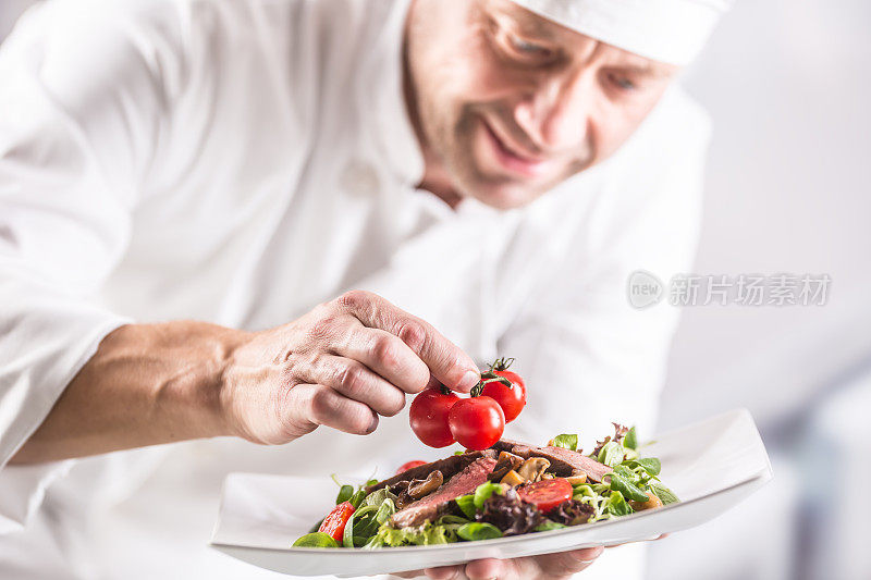 酒店或餐厅厨房的厨师在上菜前装饰食物。