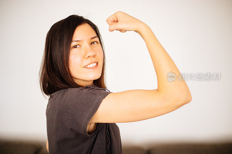 女孩的力量年轻女子展示她的手臂