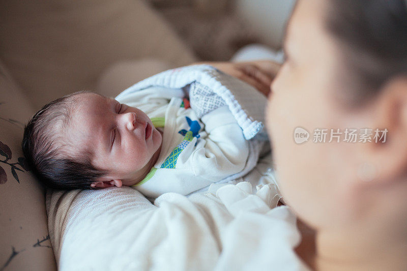 母亲用牛奶喂婴儿的照片