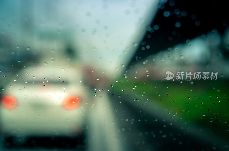 雨点落在挡风玻璃上。雨天在柏油路上行驶的汽车。汽车挡风玻璃上有雨滴。雨季交通堵塞。暴风雨天的坏天气。乘汽车旅行。