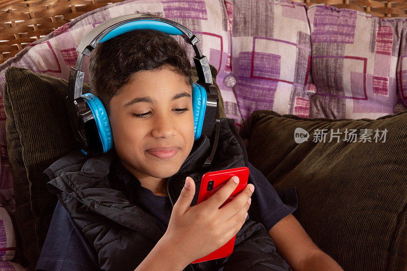 男孩用耳机听手机里的音乐
