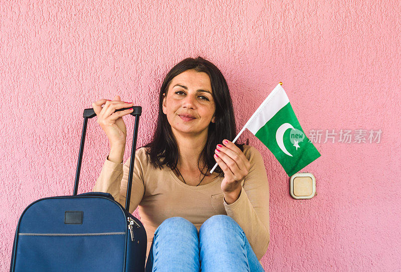 拿着旅行袋和巴基斯坦国旗的女人