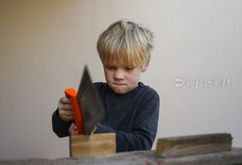 一个和木工工具一起工作的小男孩