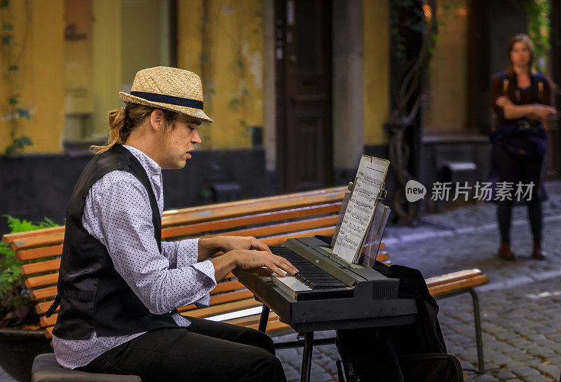 街头音乐家、电子键盘手，在瑞典斯德哥尔摩的格拉斯坦老城中部为游客演奏
