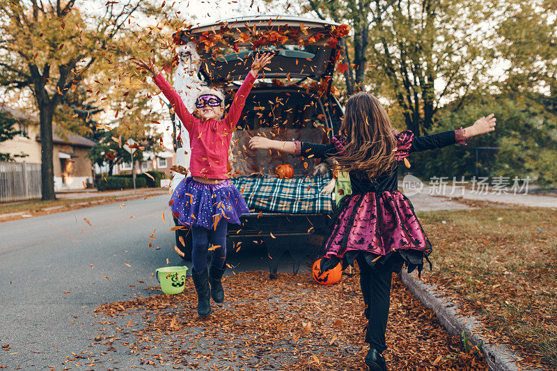 技巧或树干。孩子们，兄弟姐妹们在汽车后备箱里庆祝万圣节。朋友们，孩子们，女孩们正在为十月的户外假期做准备。社交距离和安全的替代性庆祝方式。