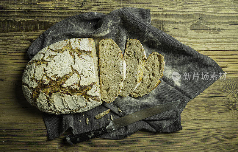 新鲜烘烤的自制“乡村风格”黑麦面包和一些薄片