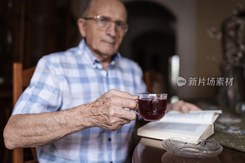 爷爷端着一杯果茶