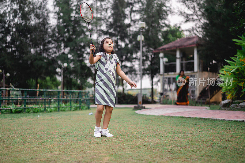 年轻女孩在公园里打羽毛球。