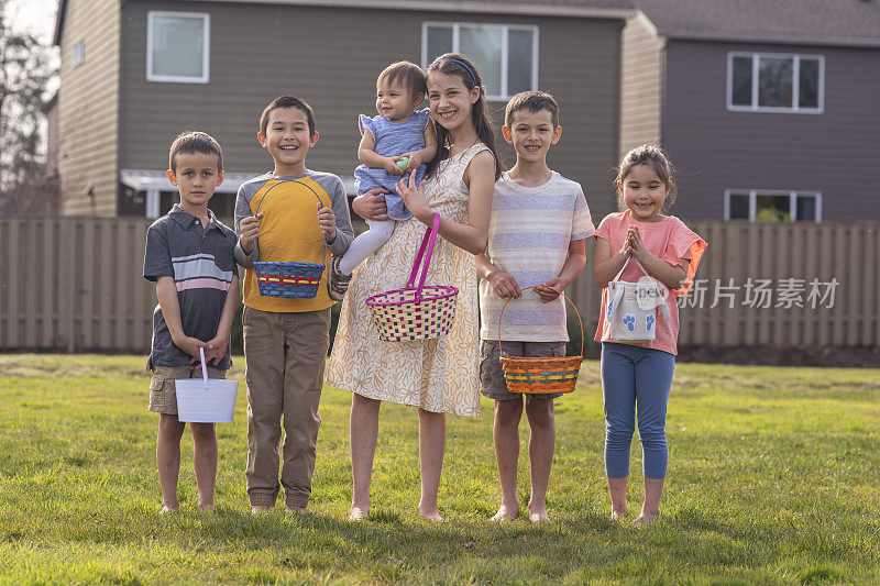 多民族不同年龄的孩子们微笑着摆出复活节篮子的姿势