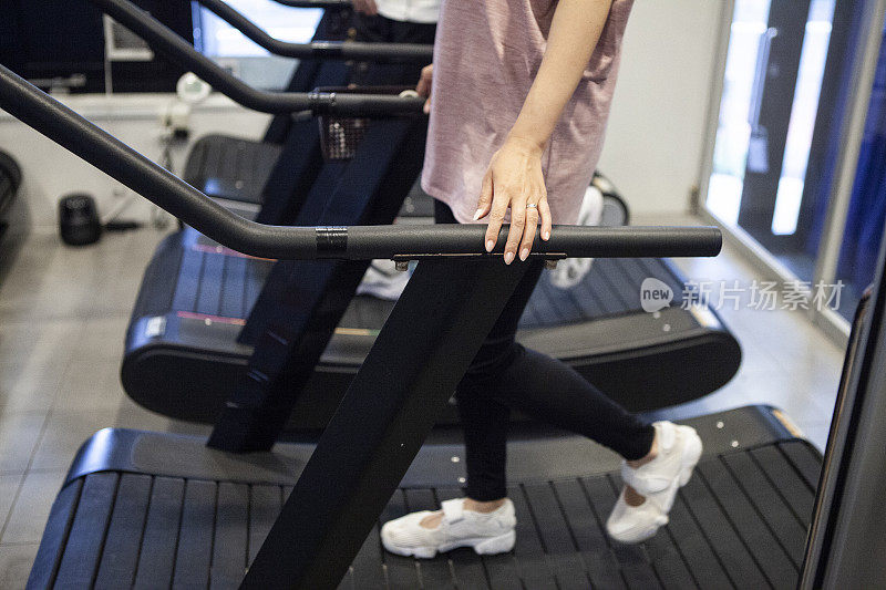 在健身房里使用跑步机的女人。