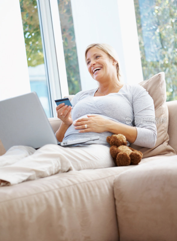 网上购物-微笑孕妇使用笔记本电脑