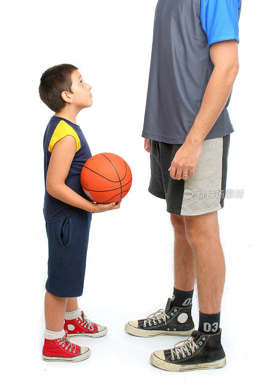 小男孩叫高个子男人在白色的地上打篮球