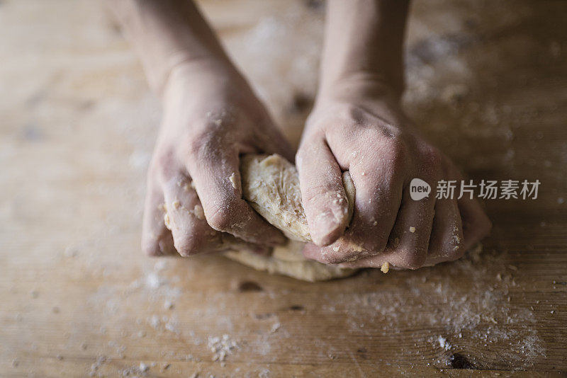 面包师的两只强壮的手揉着自制的面团