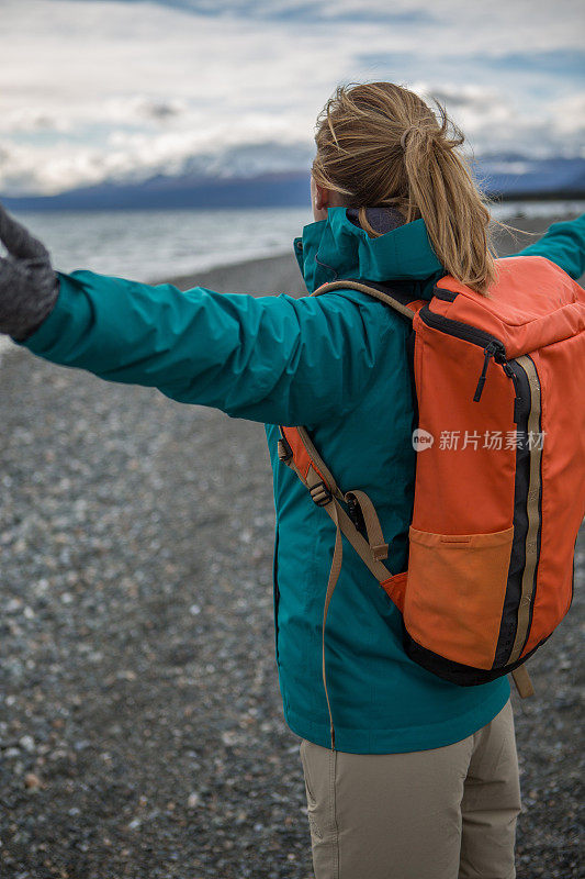 湖边的女人张开双臂——加拿大的秋天