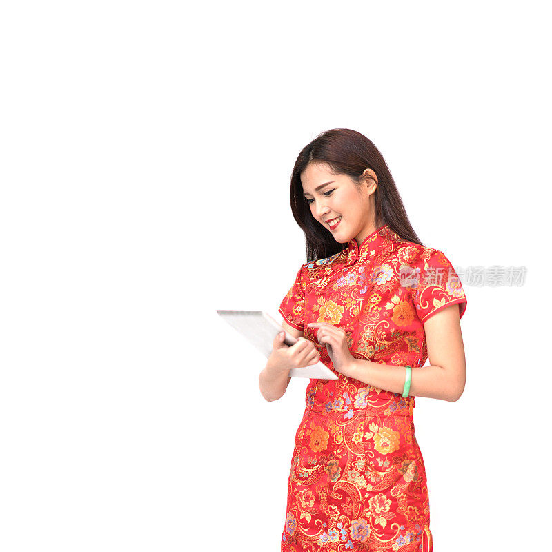 美丽的亚洲女孩穿着中国旗袍使用数字平板电脑