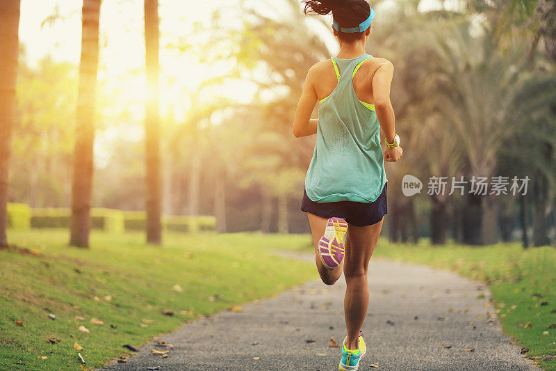 健康的生活方式年轻的运动亚洲女人在热带公园跑步