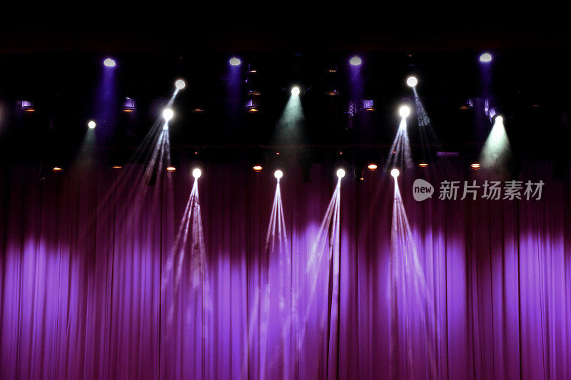 有紫色窗帘和聚光灯的剧场舞台。