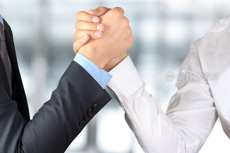 两个商人在一个向前的背景上互相握手