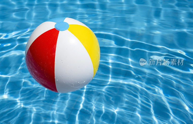一个浮在蓝色水池里的沙滩球