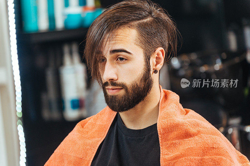 年轻英俊的男子在理发师洗完头发后留胡子