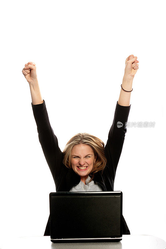 站在笔记本电脑后面的女人举起了她的胜利之手