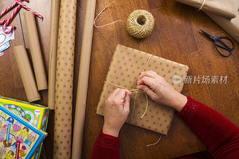 女人用牛皮纸和麻绳包装圣诞礼物