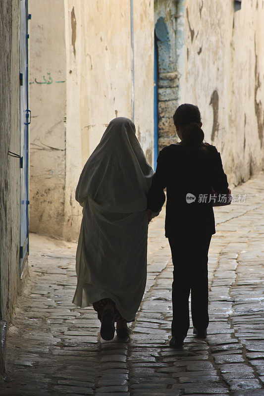 突尼斯:后方剪影中的传统和现代女性