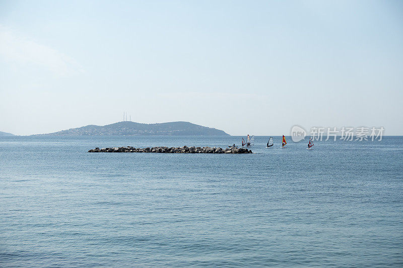 风帆冲浪者在防波堤附近冲浪
